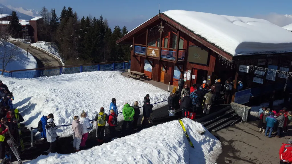 A long queue at the ski pass desks of a resort, a key touchpoint of the user journey