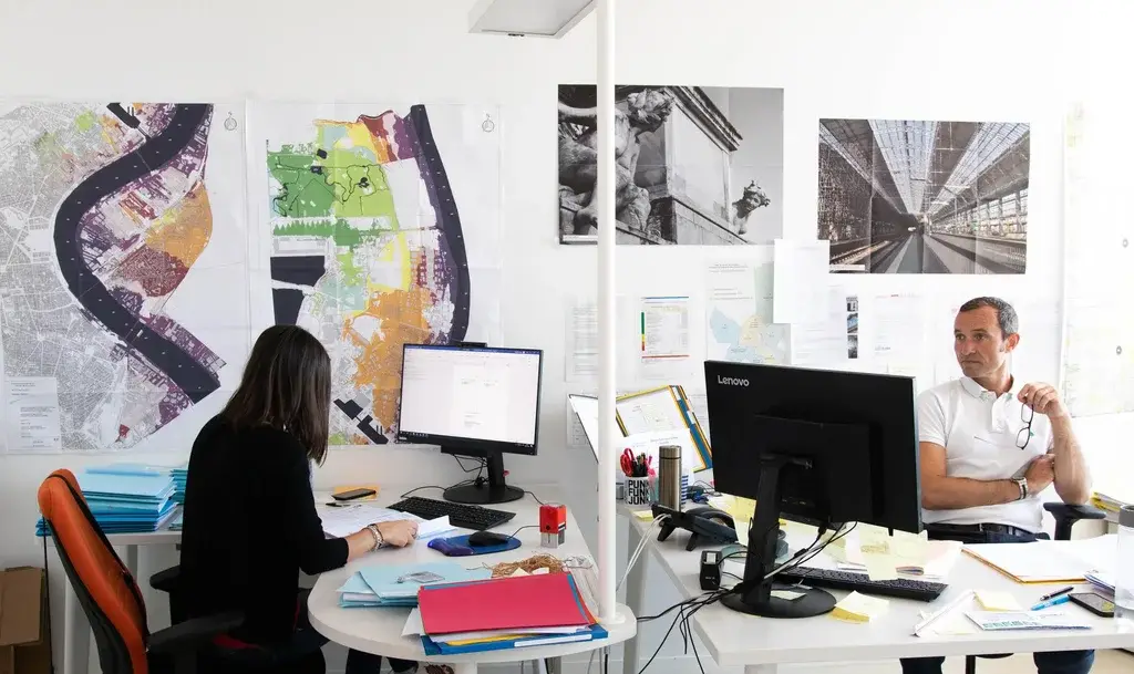 A woman and a man working on their computers in an office