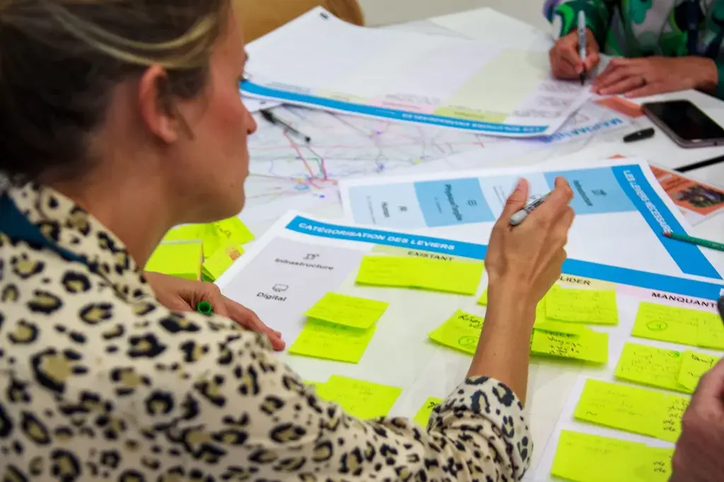 Close-up of a person annotating a working sheet with their group
