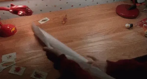 GIF de mains dépliant une grande feuille sur une table couverte de petits objets