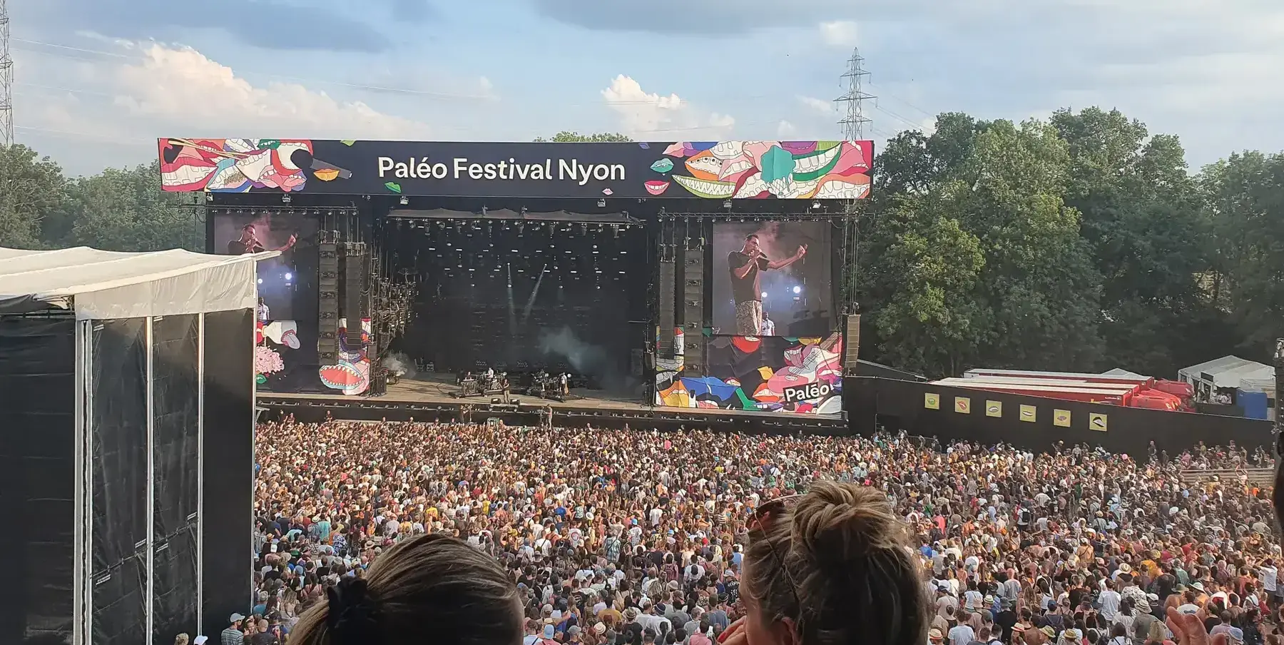Main festival stage with panels and a crowd at a concert