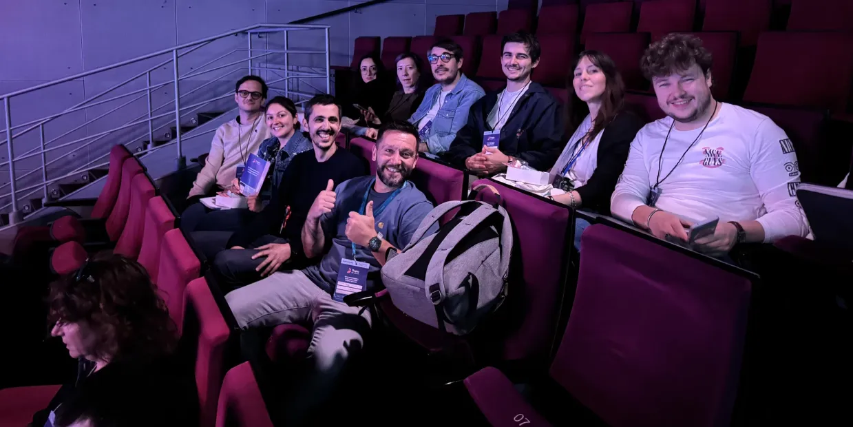 Group seated in auditorium chairs and looking toward the camera