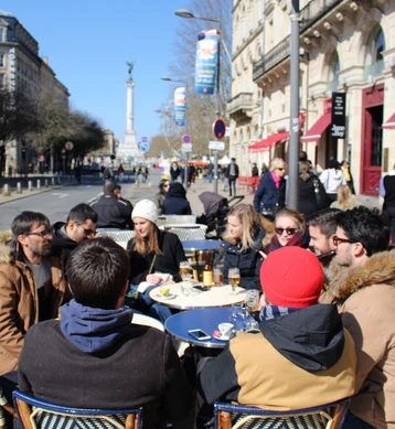 L'équipe Akiani attablée en terrasse au soleil, à proximité des Quinconces.