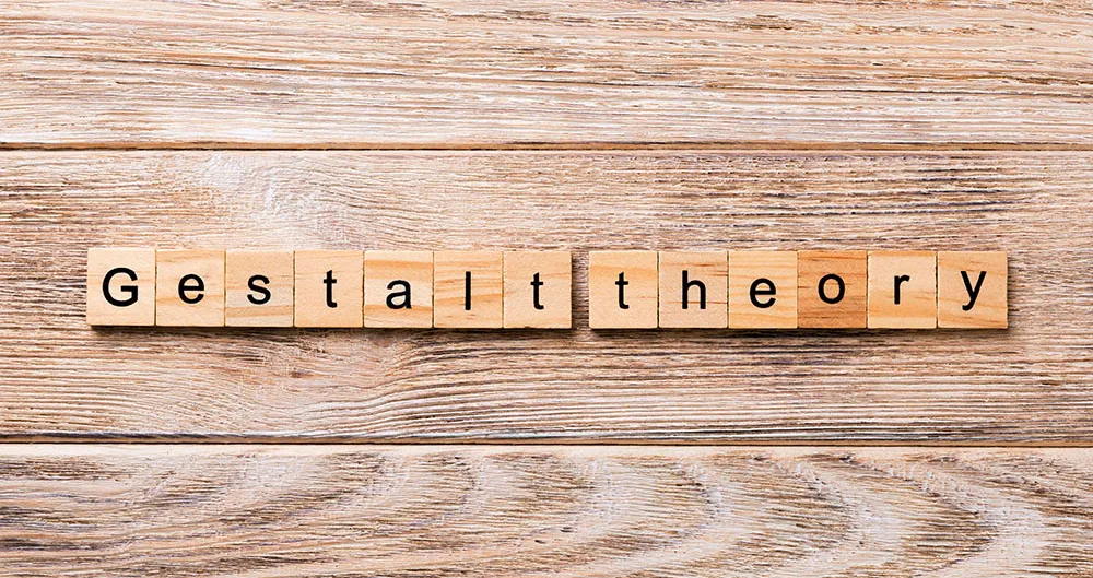 Lettres en bois épelant « Gestalt theory » sur une table en bois clair