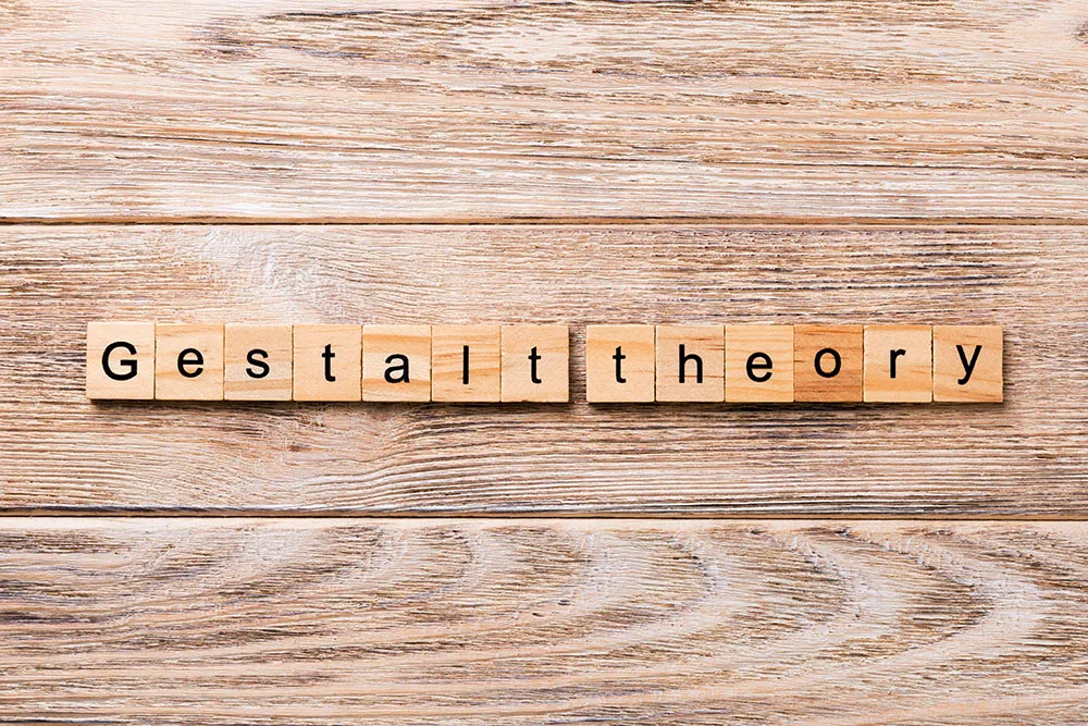 Wooden letter tiles spelling "Gestalt theory" on a pale wooden table