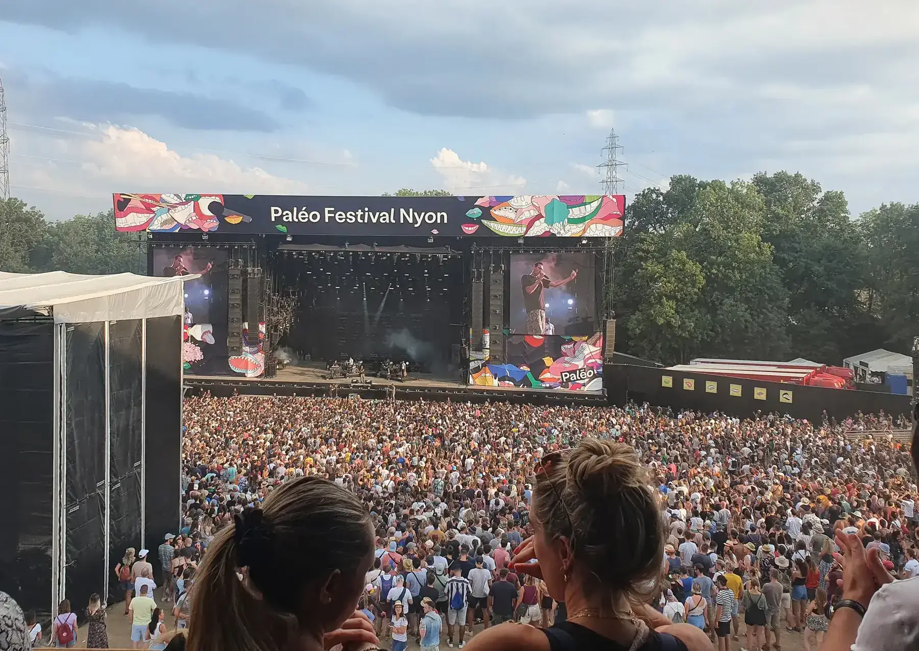 Main festival stage with panels and a crowd at a concert