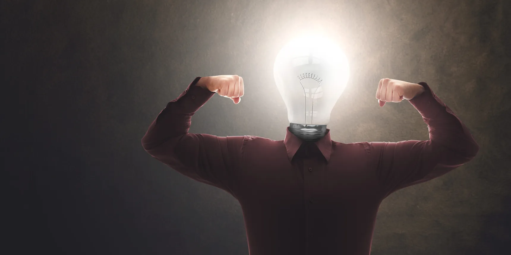 Person flexing both arms with a glowing light bulb in place of a head