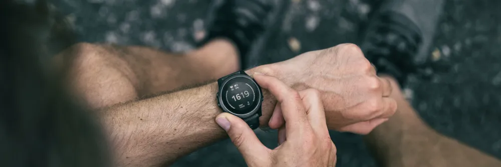 Personne touchant l'écran rond d'une montre connectée portée au poignet