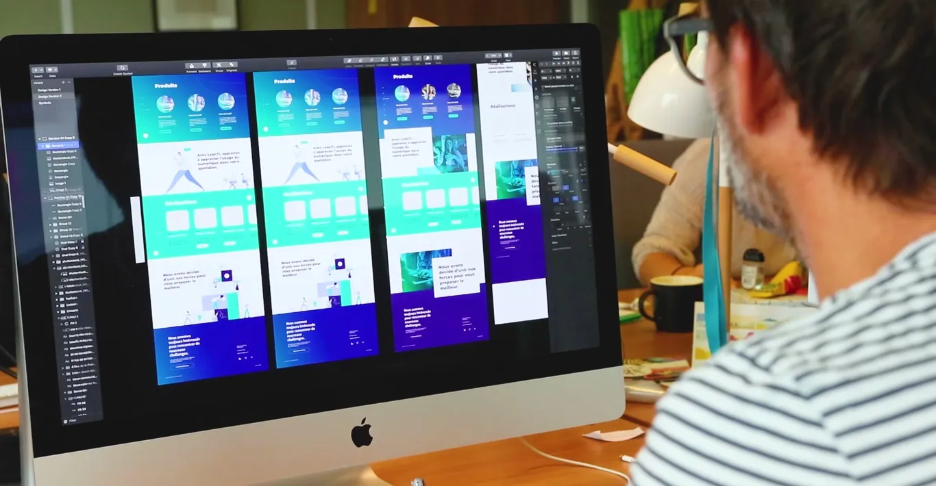 Person working on interface mockups displayed on a screen
