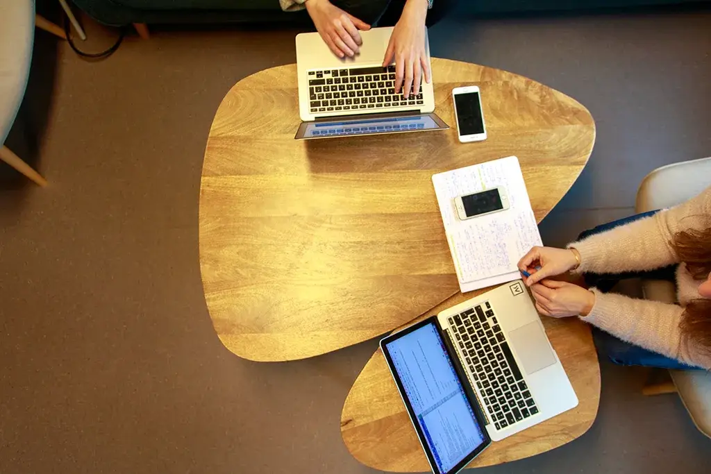Photo showing a phone and two computers from above