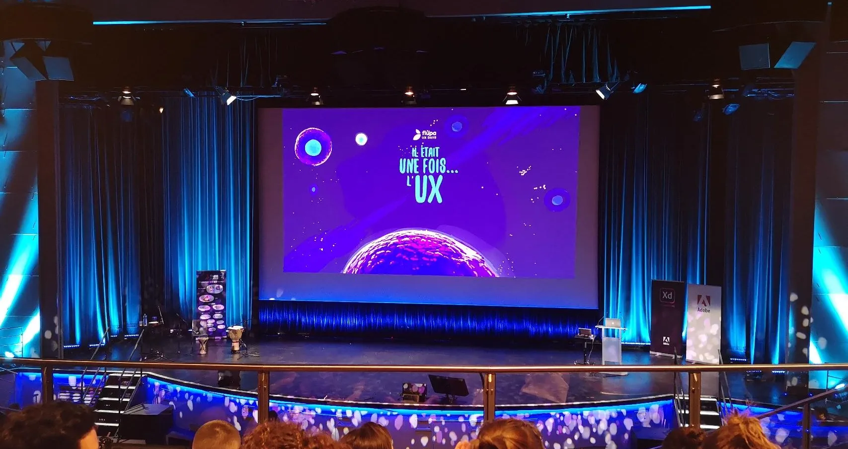 Scène de conférence affichant « UX sans frontières » devant un public assis