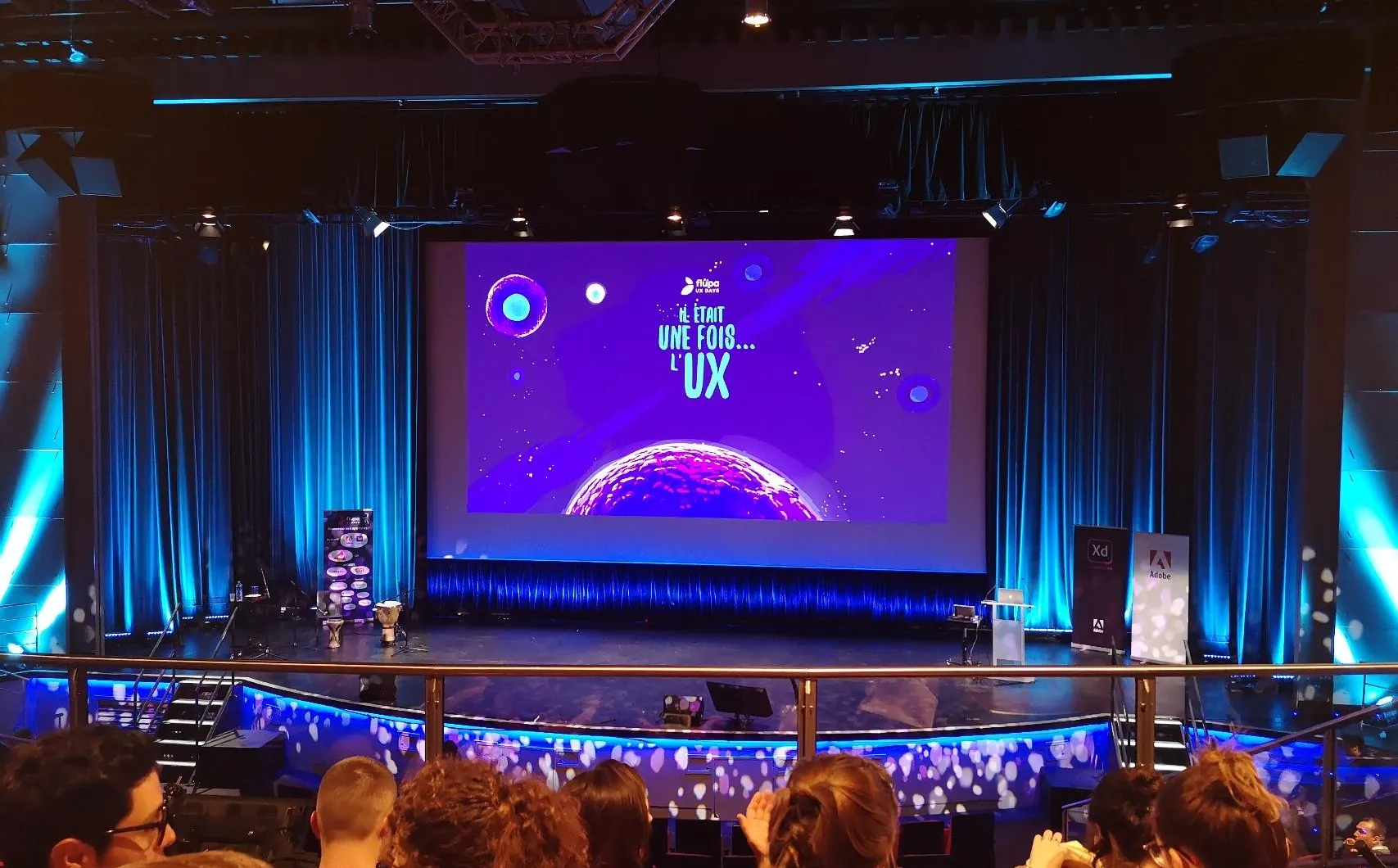 Scène de conférence affichant « UX sans frontières » devant un public assis