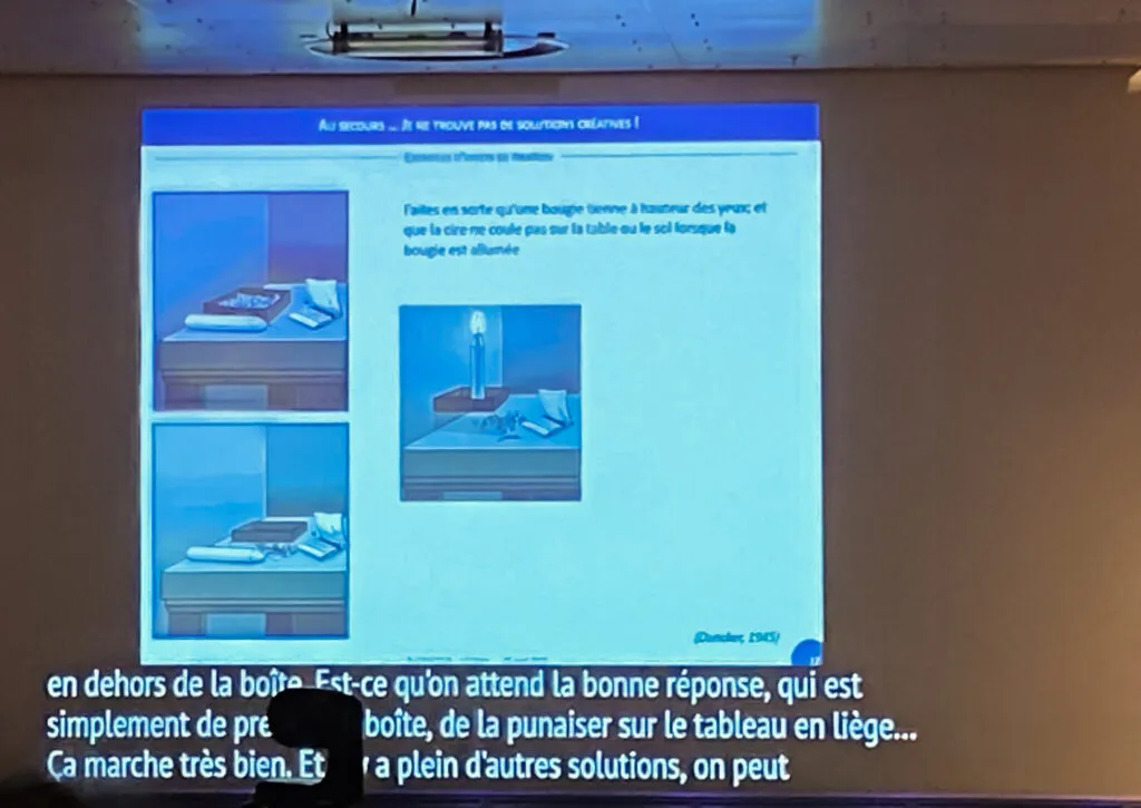 Slide showing the candle problem with the box of drawing pins