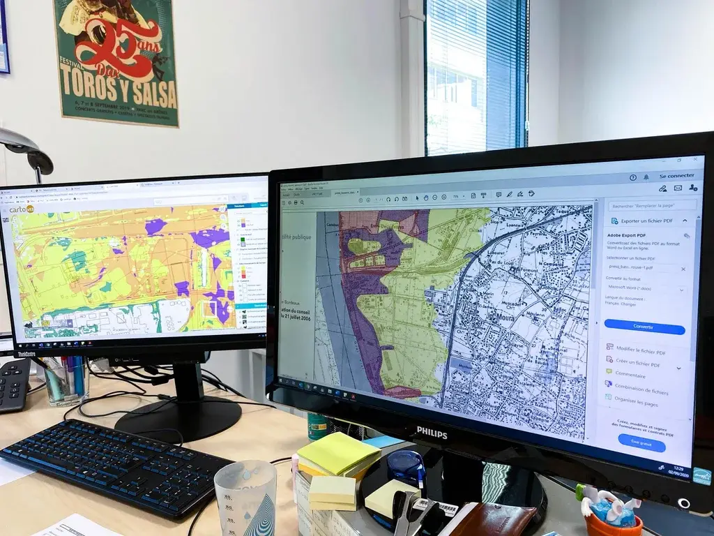 Two computers displaying planning drawings in an office