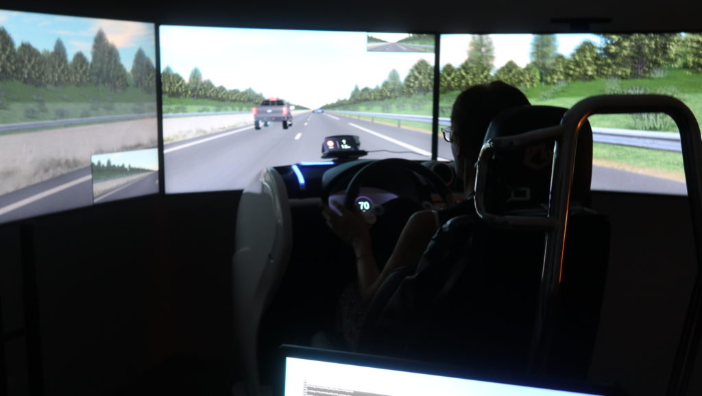 Personne assise devant un similateur de pilotage de voiture