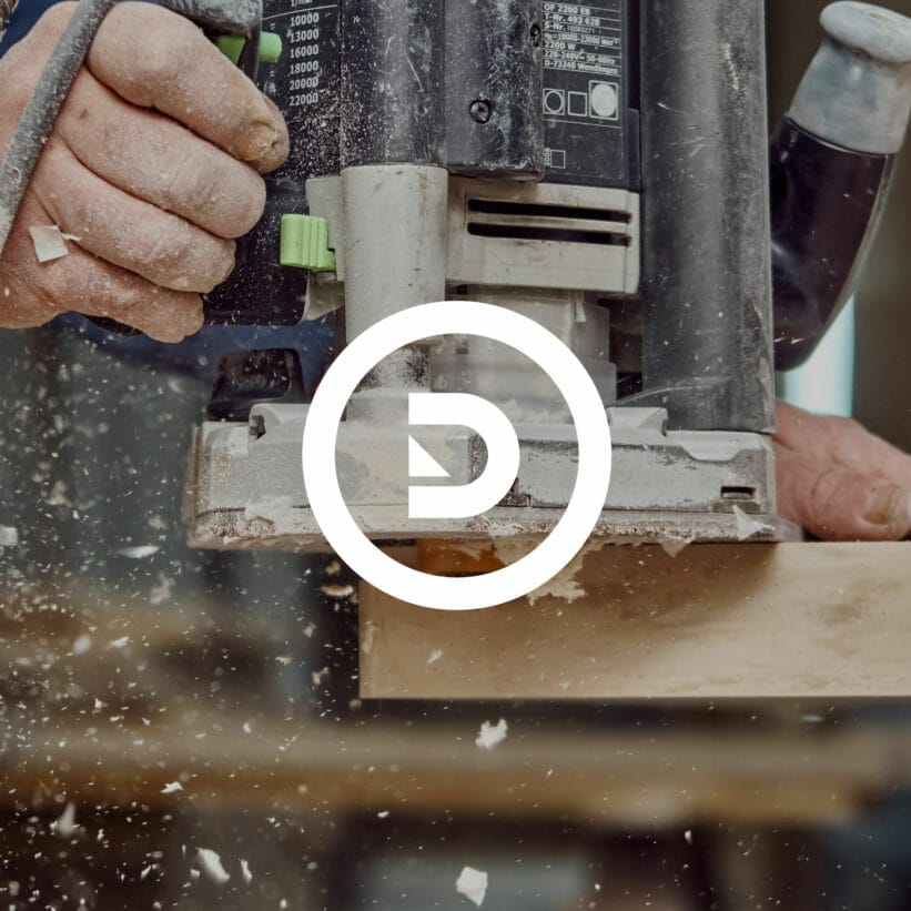 Photo d'un menuisier en plein travail avec le logo atelier duphil